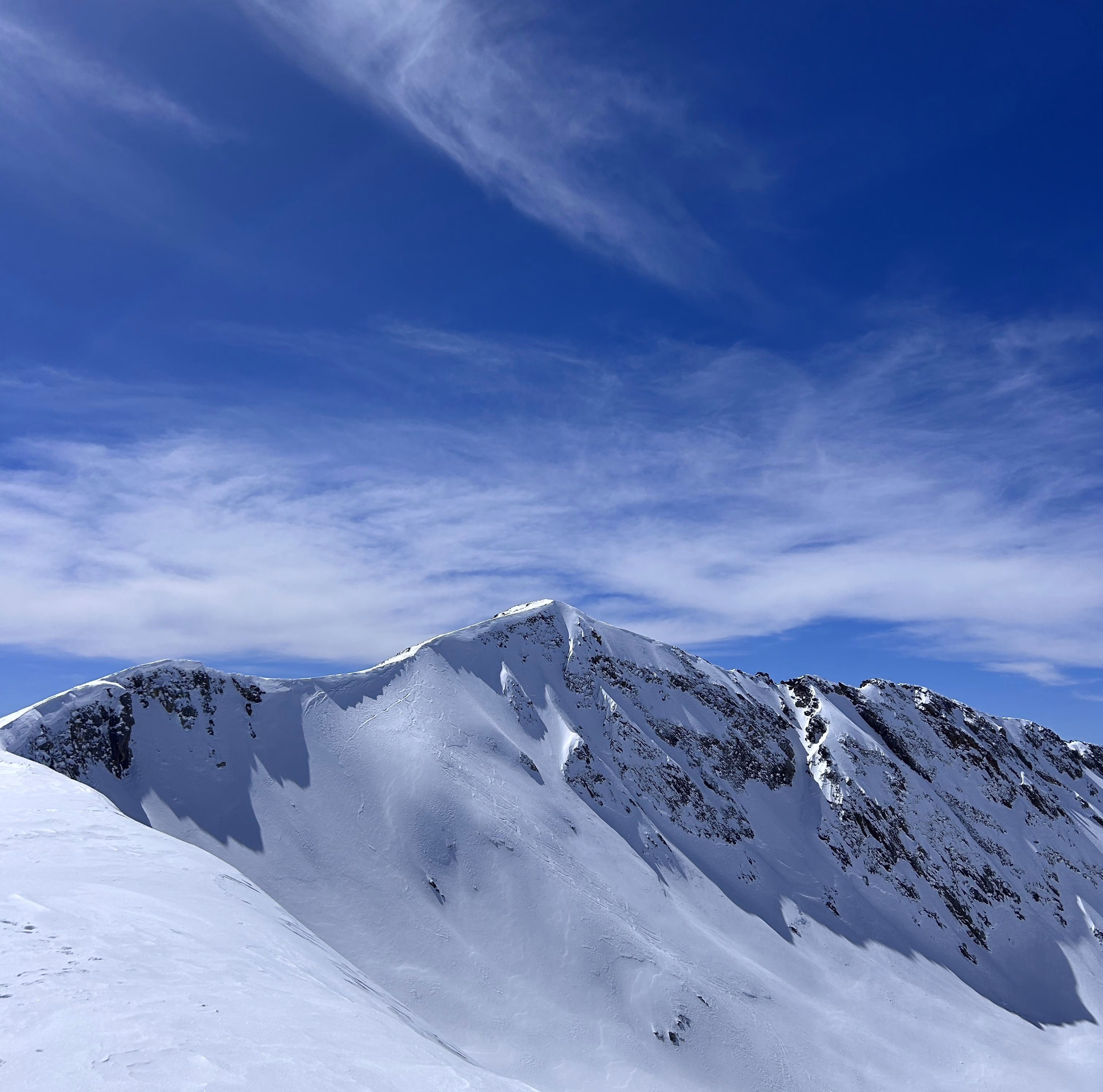Snow-covered ridge line under blue sky above Gulmarg